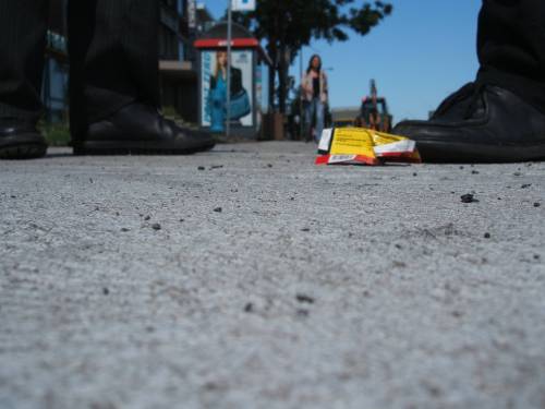 Bürgersteig mit Füßen und etwas Müll. Foto: Paul Morf Gronert